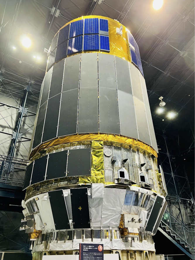 宇宙ステーションに物資を運ぶ輸送機「こうのとり」。長方形の金属が円筒形に並んでおり、上部は長方形の太陽光パネルが取り囲んでいます