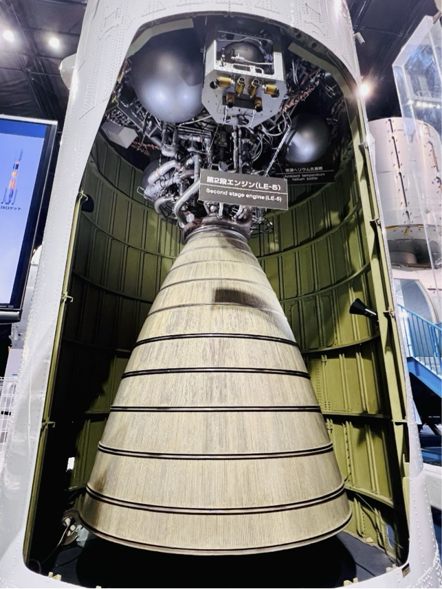 円筒形のロケット機体の一部がくり抜かれており、内部の円錐状のエンジンが見えています