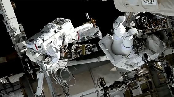 宇宙遊泳者 (左から) 若田浩一とニコール・マンは、宇宙ステーションにハードウェアを取り付けて、次の太陽電池アレイの展開に向けて周回ラボを準備しています。 クレジット: NASA TV
